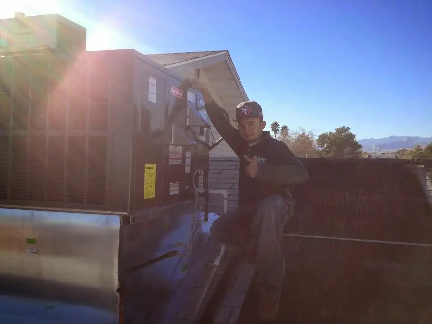 HVAC technician performing AC Tune-Up on a rooftop unit in McNair